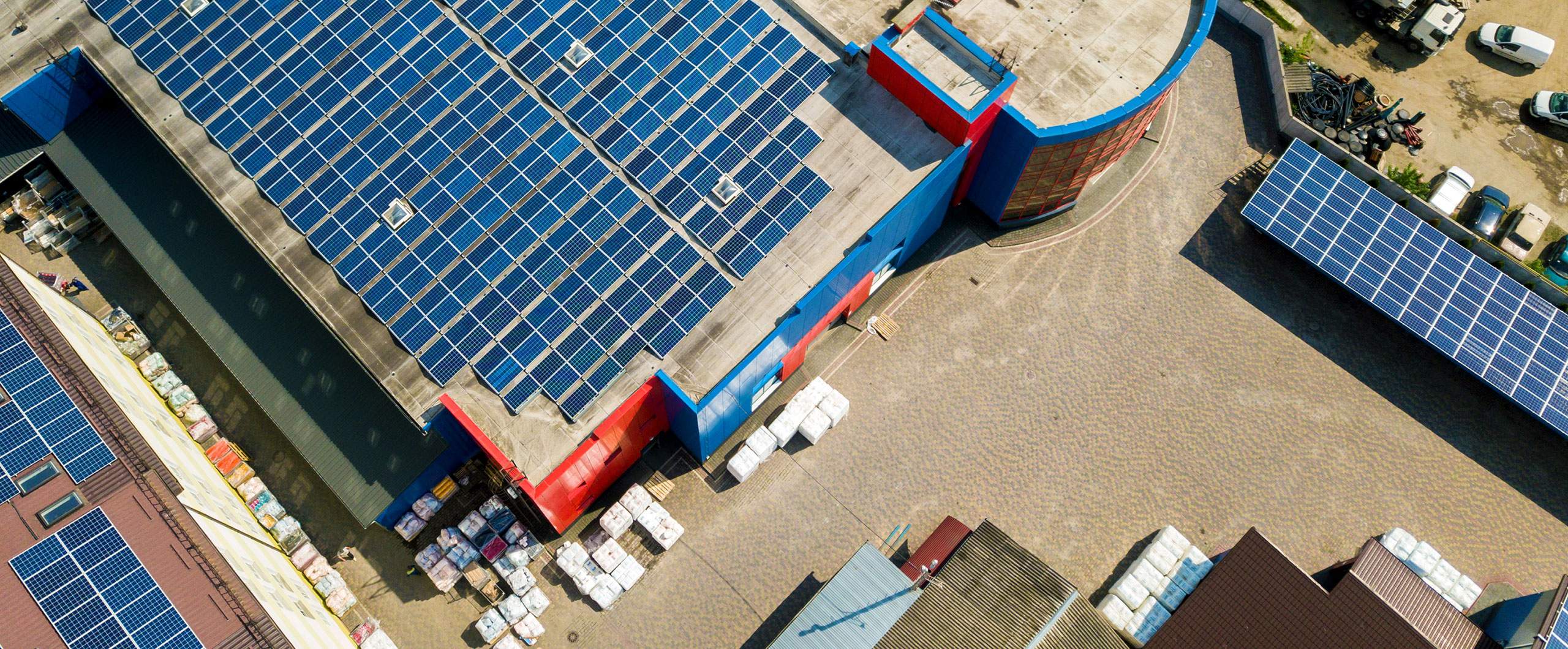 An aerial view of buildings with solar panel arrays on their roofs