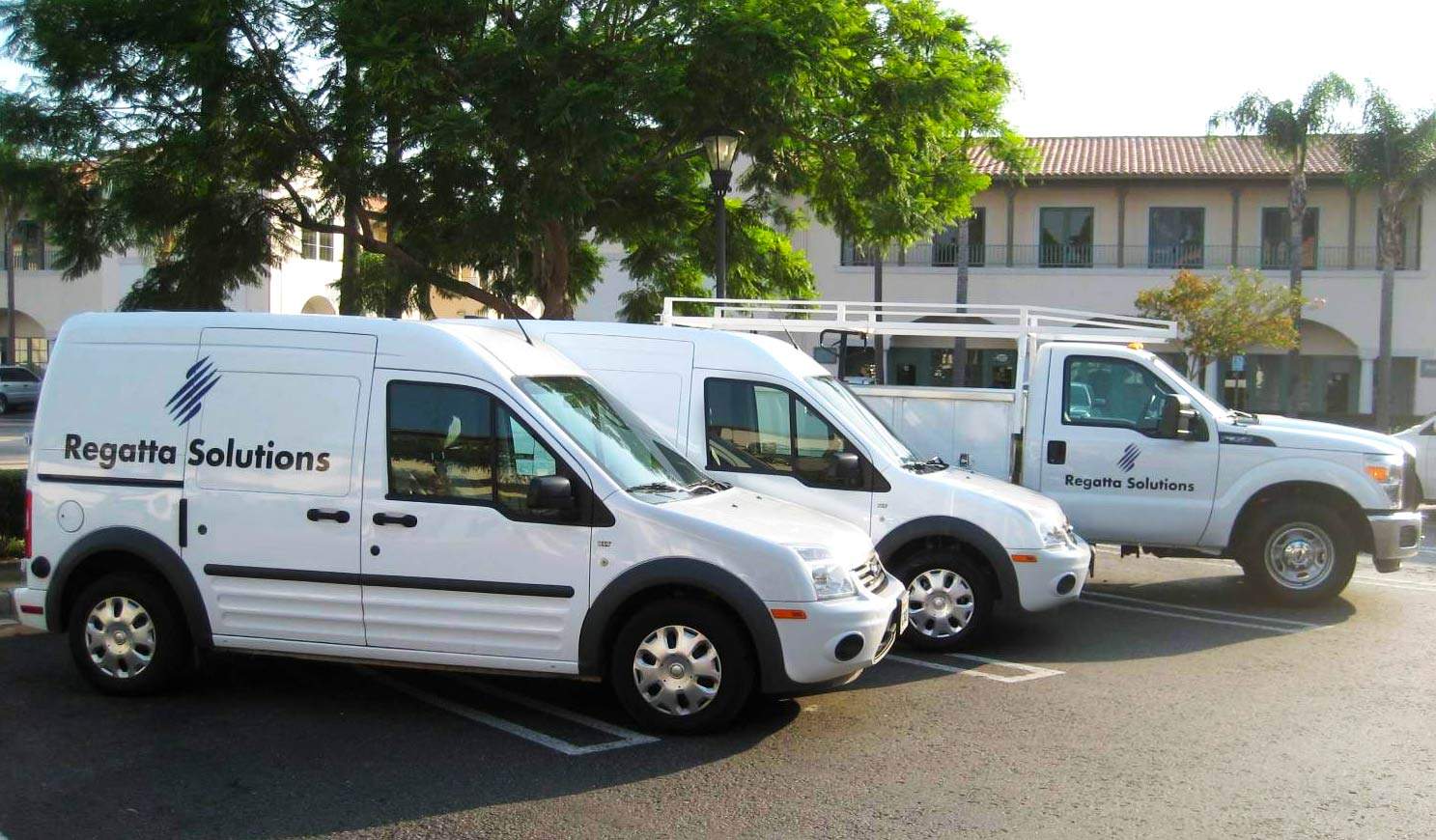 Three Regatta support vehicles in a parking lot.